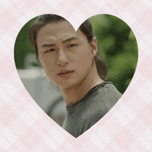 a picture of a man in a heart shaped frame on a pink background
