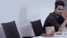 a man sitting at a table with a box on it