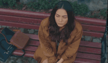 a woman sits on a park bench with the word fatih on the side