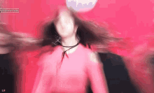 a woman in a red dress is dancing on a stage with her hair in the air .