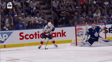 a hockey game is being played in front of an advertisement for scotch bank