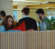 a group of people are sitting around a table behind a fence