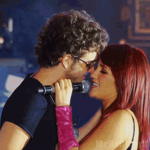 a man and a woman are kissing in front of a microphone with the word mafia on the bottom