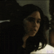 a woman is laying on a bed in a dark room .