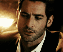 a close up of a man 's face with a beard wearing a suit and tie