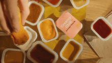 a person dipping a chicken nugget in a creamy chili sauce