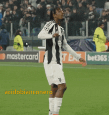 a soccer player stands on a field in front of a mastercard ad