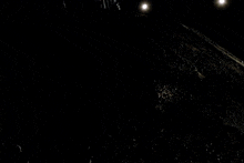 a person standing on top of a pile of rocks with a light shining on them