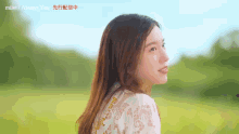 a woman in a white dress stands in a field with chinese writing on the bottom