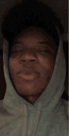 a man wearing a hooded sweatshirt is smiling and looking up