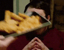 a man is cutting french fries with a knife .