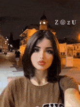 a young woman is taking a selfie in front of a building at night .