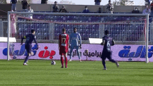 soccer players on a field with advertisements for mesh24