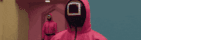 a man in a pink suit with a mask on his face is walking down a hallway .