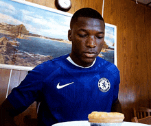 a man in a blue nike shirt looks at a pie