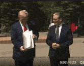 two men in suits and ties are standing next to each other with 0:02 / 0.23 on the bottom of the screen