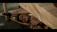 a woman is tied up and laying on the floor with blood coming out of her mouth .