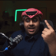 a man wearing headphones and a rode microphone makes a funny face