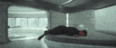 a man is laying on a round bed in a room