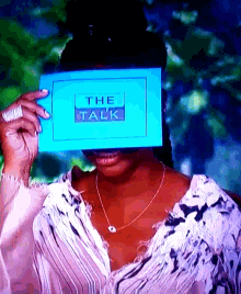 a woman covering her face with a card that says the talk