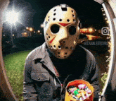 a person wearing a jason voorhees mask is holding a bag of candy