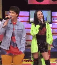 a man singing into a microphone next to a woman