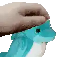 a person is putting a hat on a stuffed dolphin 's head .
