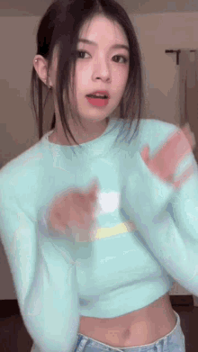 the girl is wearing a blue sweater and jeans and is dancing .