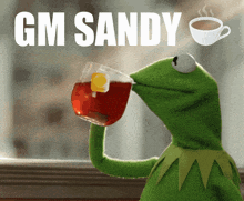 kermit the frog drinking a cup of tea with the words gm sandy written above him