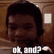 a boy wearing a headset says ok and