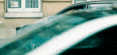a car is parked in front of a building with a sign on the window that says haynan