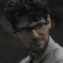 a close up of a man wearing glasses and a tie