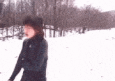 a person is walking in the snow with trees in the background