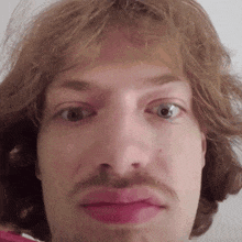 a close up of a man 's face with a mustache and pink lips