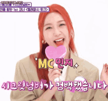a woman with red hair is holding a pink heart shaped lollipop and says mc in pink letters
