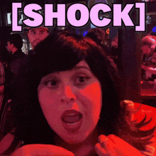 a woman with a surprised look on her face with the word shock behind her