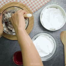 a person is mixing ingredients in a glass bowl with a wooden spoon and the words mr. cakes visible in the corner