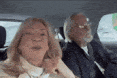 a man and a woman are in the back seat of a car