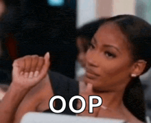 a woman is making a funny face and the word oops is on the bottom of the picture .