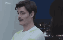 a man with a mustache is looking at a woman with the word film on the bottom right