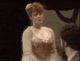 a woman is standing next to a man in a dark room .