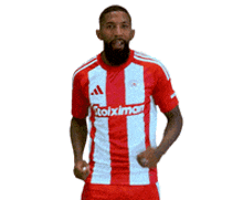 a man wearing a red and white striped shirt that says stoixima on it
