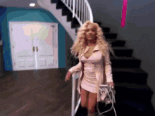 a woman in a white dress is walking down stairs