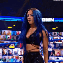 a woman with blue hair is standing in a ring .