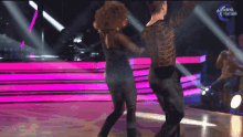 a man and a woman are dancing in front of a sign that says " dancing brasil "
