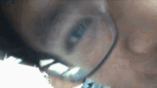 a close up of a person wearing glasses with a blue eye
