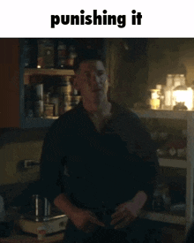 a man in a black shirt is standing in a kitchen with a caption that says punishing it