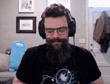 a man with a beard wearing headphones and a cat shirt