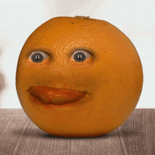 an orange with a face carved into it sits on a table