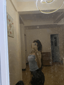 a woman is taking a selfie in a mirror with her phone